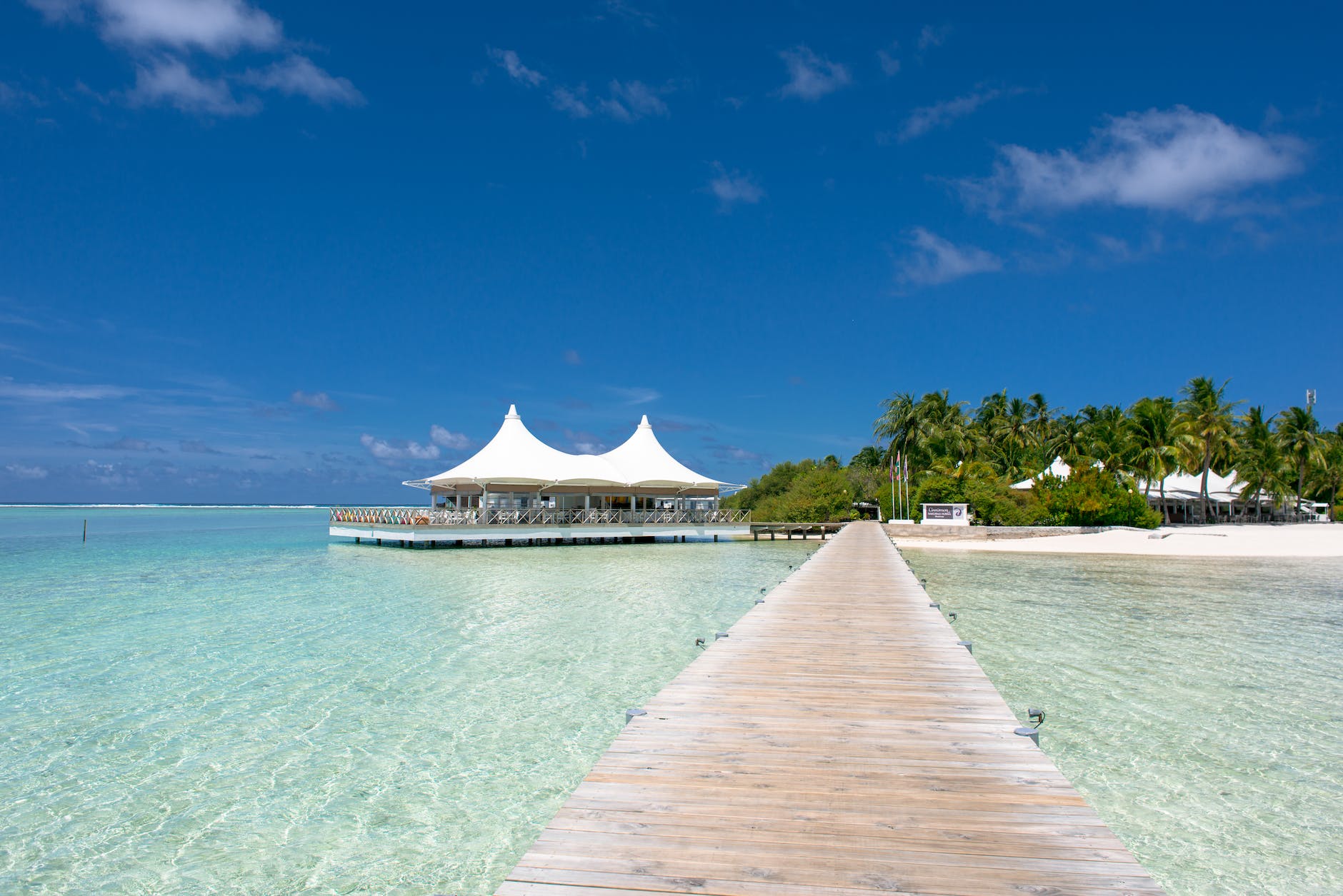 beach dock near hut under blue skies